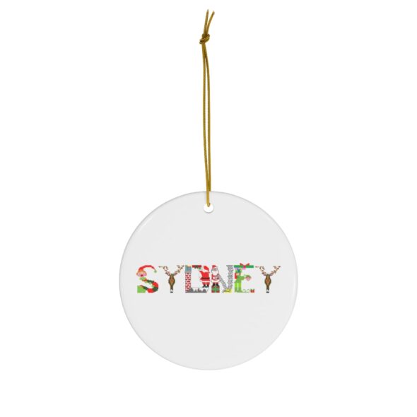 White ceramic ornament with text ‘Sydney’ in colourful Christmas themed lettering, with gold hanging loop