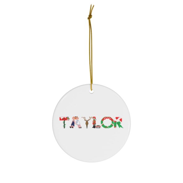 White ceramic ornament with text ‘Taylor’ in colourful Christmas themed lettering, with gold hanging loop
