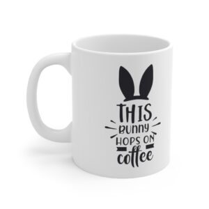 White 11 ounce mug with black bunny ears and. whiskers graphic that reads ‘this bunny hops on coffee’
