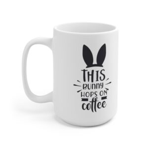 White 15 ounce mug with black bunny ears and. whiskers graphic that reads ‘this bunny hops on coffee’