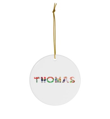 White ceramic ornament with text ‘Thomas’ in colourful Christmas themed lettering, with gold hanging loop