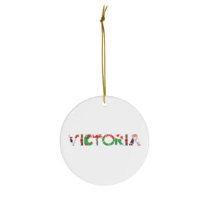 White ceramic ornament with text ‘Victoria’ in colourful Christmas themed lettering, with gold hanging loop
