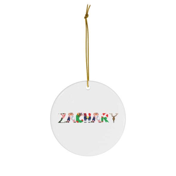 White ceramic ornament with text ‘Zachary’ in colourful Christmas themed lettering, with gold hanging loop